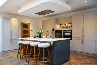 Photo of a large traditional kitchen/diner in Cornwall with shaker cabinets, grey cabinets, composite countertops and an island.