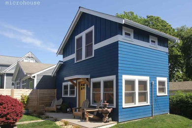 Immagine della villa piccola blu classica a due piani con rivestimento con lastre in cemento, tetto a capanna e copertura a scandole