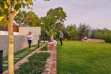 Inspiration for a large modern backyard full sun formal garden for fall in Perth with a fire feature and brick pavers.