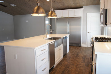 Beach style kitchen photo in Orlando with flat-panel cabinets, white cabinets, wood countertops, white backsplash and an island