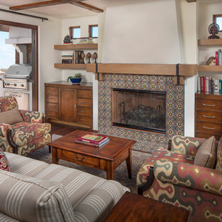 Diseño de salón mediterráneo con chimenea tradicional y marco de chimenea de baldosas y/o azulejos