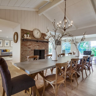 Große Landhausstil Wohnküche mit weißer Wandfarbe, Tunnelkamin, Kaminsims aus Backstein und braunem Holzboden in San Diego