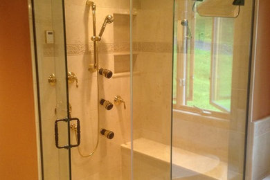 Mid-sized elegant master beige tile and ceramic tile ceramic tile and beige floor bathroom photo in Burlington with orange walls and a hinged shower door