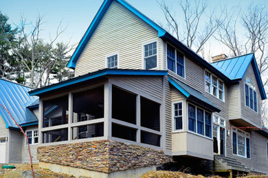 Example of a large beige two-story wood exterior home design in Burlington with a hip roof