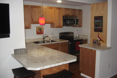 Inspiration for a small timeless l-shaped laminate floor and brown floor eat-in kitchen remodel with a double-bowl sink, shaker cabinets, light wood cabinets, laminate countertops, gray backsplash, ceramic backsplash, stainless steel appliances and a peninsula