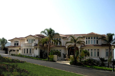 Large mediterranean beige two-story stucco house exterior idea in San Francisco with a hip roof and a tile roof