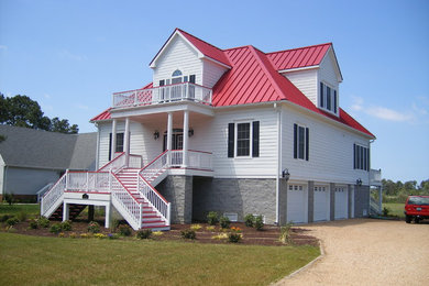 Mid-sized transitional multicolored three-story mixed siding house exterior photo in Other with a clipped gable roof and a metal roof
