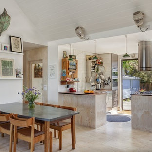 Idées déco pour une salle à manger ouverte sur la cuisine bord de mer avec un mur blanc, un sol en contreplaqué et un sol beige.