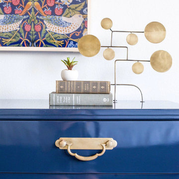 Blue Dresser Styling with Brass Accents and Botanical Artwork