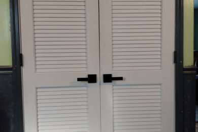 French style louver interior door with contemporary knobs.