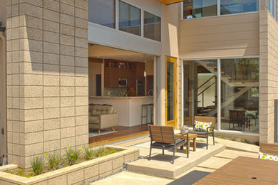 Large minimalist beige two-story stucco flat roof photo in San Diego