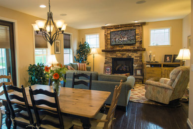 Photo of a mid-sized traditional open plan dining in Denver with beige walls, dark hardwood floors, a standard fireplace and a stone fireplace surround.