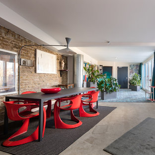 This is an example of an eclectic open plan dining in Berlin with white walls, concrete floors and grey floor.