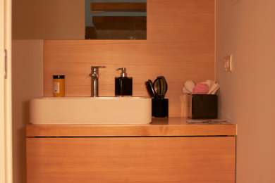 This is an example of a modern bathroom in Venice with wood benchtops.