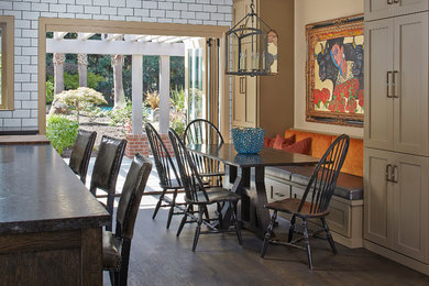 Mid-sized elegant l-shaped dark wood floor and brown floor eat-in kitchen photo in San Francisco with a farmhouse sink, shaker cabinets, dark wood cabinets, limestone countertops, white backsplash, subway tile backsplash, paneled appliances and an island