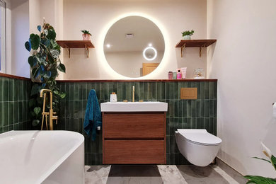 Photo of a medium sized contemporary family bathroom in Manchester with flat-panel cabinets, dark wood cabinets, a freestanding bath, a wall mounted toilet, green tiles, porcelain tiles, beige walls, porcelain flooring, an integrated sink, wooden worktops, white floors, brown worktops, a wall niche, a single sink and a floating vanity unit.