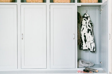 Large country mudroom in Baltimore with grey walls, light hardwood floors and a black front door.