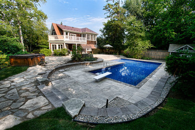 Large mountain style backyard tile and l-shaped pool house photo in Ottawa