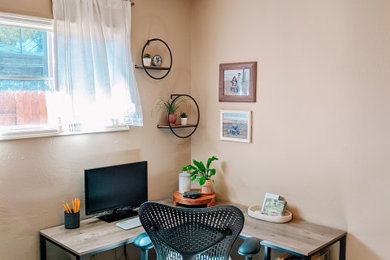 Imagen de despacho ecléctico de tamaño medio con paredes beige, suelo de madera en tonos medios, escritorio independiente y suelo marrón
