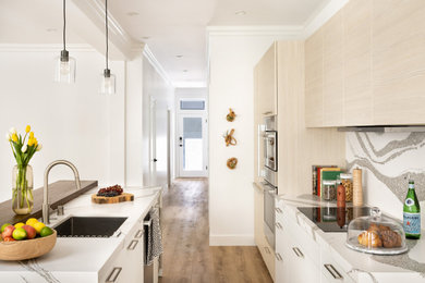 Kitchen - contemporary kitchen idea in San Francisco with an undermount sink, flat-panel cabinets, light wood cabinets, quartz countertops, multicolored backsplash, quartz backsplash, stainless steel appliances, an island and multicolored countertops