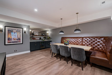Inspiration for a transitional vinyl floor and brown floor basement remodel in Chicago with gray walls