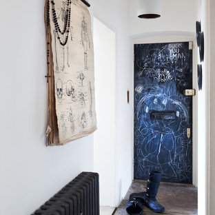 Inspiration for a small eclectic entry hall in London with white walls and concrete floors.