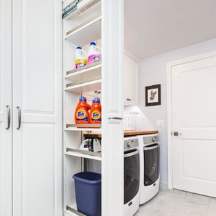 Inspiration for a classic utility room in San Francisco with raised-panel cabinets, white cabinets, grey walls and a side by side washer and dryer.
