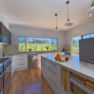 Large modern kitchen pantry inspiration - Large minimalist l-shaped dark wood floor and brown floor kitchen pantry photo in Adelaide with a single-bowl sink, white cabinets, quartz countertops, beige backsplash, ceramic backsplash, stainless steel appliances and an island