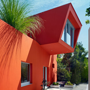 Выдающиеся фото от архитекторов и дизайнеров интерьера: двухэтажный фасад частного дома оранжевого цвета в современном стиле