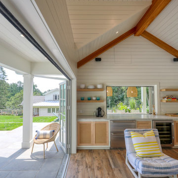 Pool house kitchen with FoldFlat pass-through window and folding doors open to t