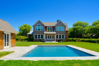Large elegant brown two-story wood exterior home photo in New York with a shingle roof