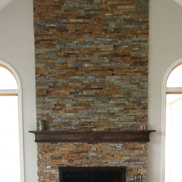 Two Toned Kitchen with White Island and Great Room Stacked Stone Fireplace