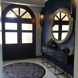 Idée de décoration pour une grande entrée bohème avec un couloir, un mur bleu, un sol en carrelage de céramique, une porte double et une porte noire.