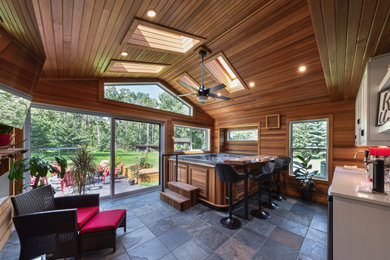Example of a mid-sized mountain style ceramic tile and multicolored floor sunroom design in Edmonton with a standard fireplace, a tile fireplace and a skylight