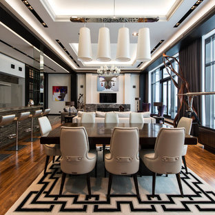 Пример оригинального дизайна: гостиная-столовая в современном стиле с белыми стенами, паркетным полом среднего тона и коричневым полом