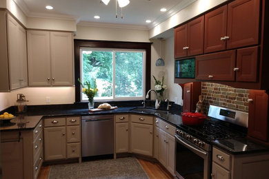 Inspiration for a mid-sized timeless u-shaped medium tone wood floor and brown floor open concept kitchen remodel in Other with a double-bowl sink, recessed-panel cabinets, gray cabinets, quartz countertops, brown backsplash, brick backsplash, stainless steel appliances, no island and black countertops