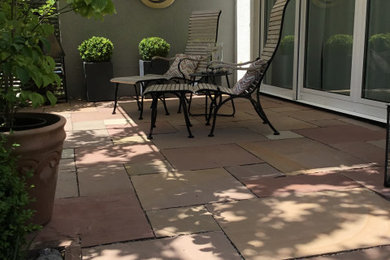 Design ideas for a small country side yard patio with natural stone pavers.
