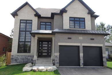 This is an example of a large transitional two-storey beige house exterior in Toronto with stone veneer.