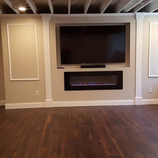 Design ideas for a medium sized traditional look-out basement in Boston with beige walls, dark hardwood flooring, a ribbon fireplace, a plastered fireplace surround and brown floors.
