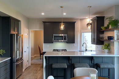 Example of a transitional porcelain tile and brown floor kitchen design in Denver with an undermount sink, quartzite countertops, gray backsplash, porcelain backsplash, stainless steel appliances and white countertops