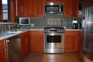Example of a mid-sized arts and crafts medium tone wood floor eat-in kitchen design in Los Angeles with an undermount sink, shaker cabinets, medium tone wood cabinets, quartz countertops, green backsplash, ceramic backsplash and stainless steel appliances