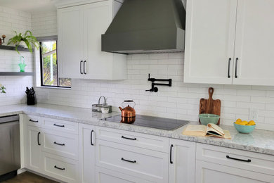 Inspiration for a mid-sized country u-shaped vinyl floor and beige floor kitchen remodel in Sacramento with shaker cabinets, white cabinets, quartz countertops, white backsplash, ceramic backsplash, stainless steel appliances, an island and gray countertops