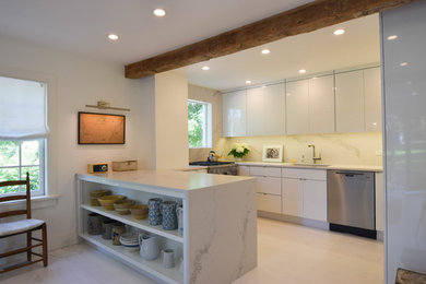Eat-in kitchen - modern eat-in kitchen idea in New York with an undermount sink, flat-panel cabinets, white cabinets, quartz countertops, white backsplash, stone slab backsplash, stainless steel appliances, an island and white countertops