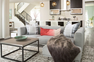 Example of a trendy medium tone wood floor living room design in Seattle with beige walls, a standard fireplace, a stone fireplace and a wall-mounted tv