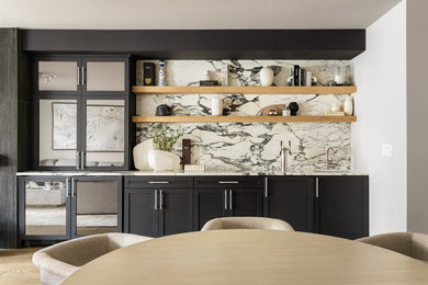 Large trendy single-wall light wood floor wet bar photo in Philadelphia with an undermount sink, shaker cabinets, black cabinets, marble countertops and marble backsplash