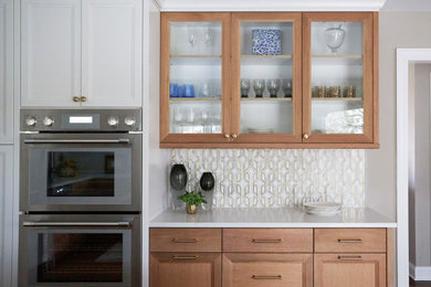 Kitchen - modern kitchen idea in Chicago with a single-bowl sink, glass-front cabinets, quartzite countertops, white backsplash, stone tile backsplash, paneled appliances, an island and white countertops
