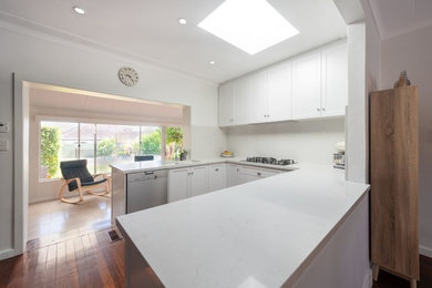 Inspiration for a small modern u-shaped open plan kitchen in Perth with an undermount sink, shaker cabinets, white cabinets, quartz benchtops, white splashback, stone slab splashback, stainless steel appliances, no island and white benchtop.