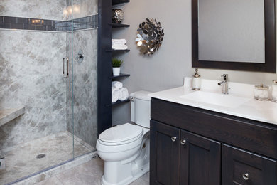 Design ideas for a large transitional 3/4 bathroom in San Diego with shaker cabinets, dark wood cabinets, an alcove shower, a two-piece toilet, gray tile, stone slab, porcelain floors, an integrated sink, engineered quartz benchtops, beige floor, a hinged shower door and grey walls.