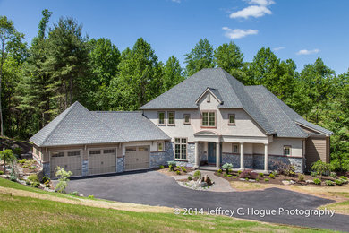 Huge 1960s beige two-story stucco exterior home photo in Philadelphia