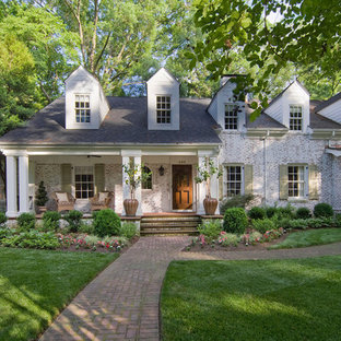 Klassisk inredning av ett mellanstort vitt hus, med två våningar och tegel